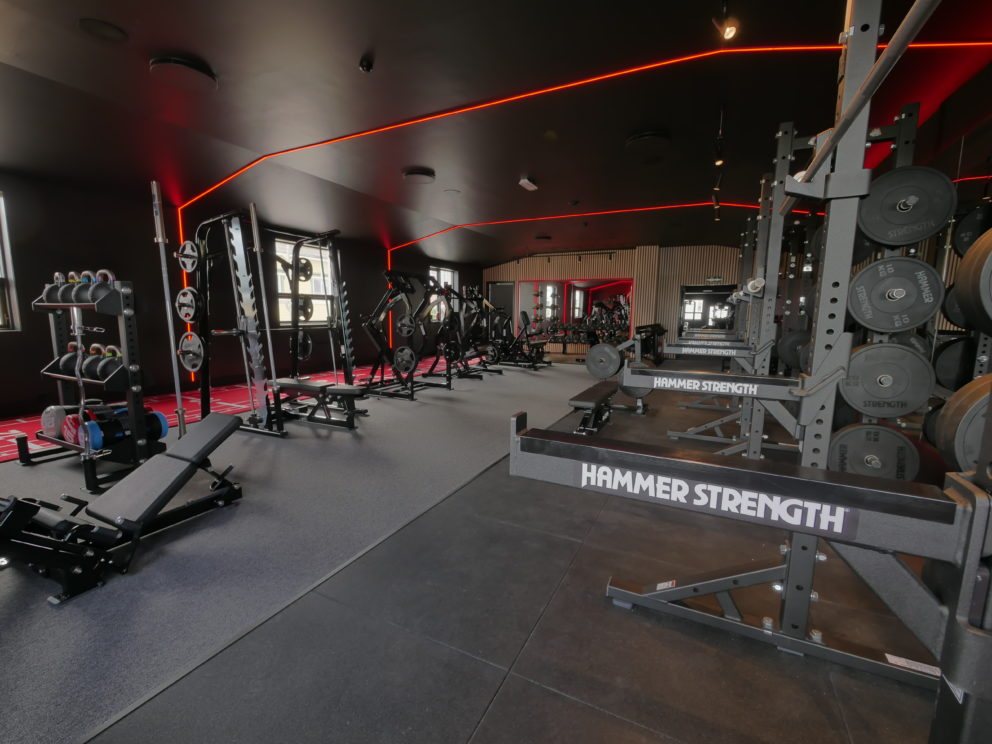 Treningssenteret med Hammer Strength-stativer og rødt lys